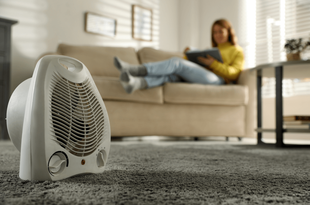 woman using heater in winter