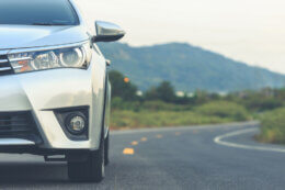 a silver car driving on a mountain road
