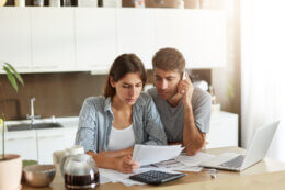 Young couple looking at bills worriedly