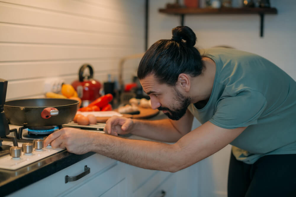 Man preparing breakfast with a gas stove