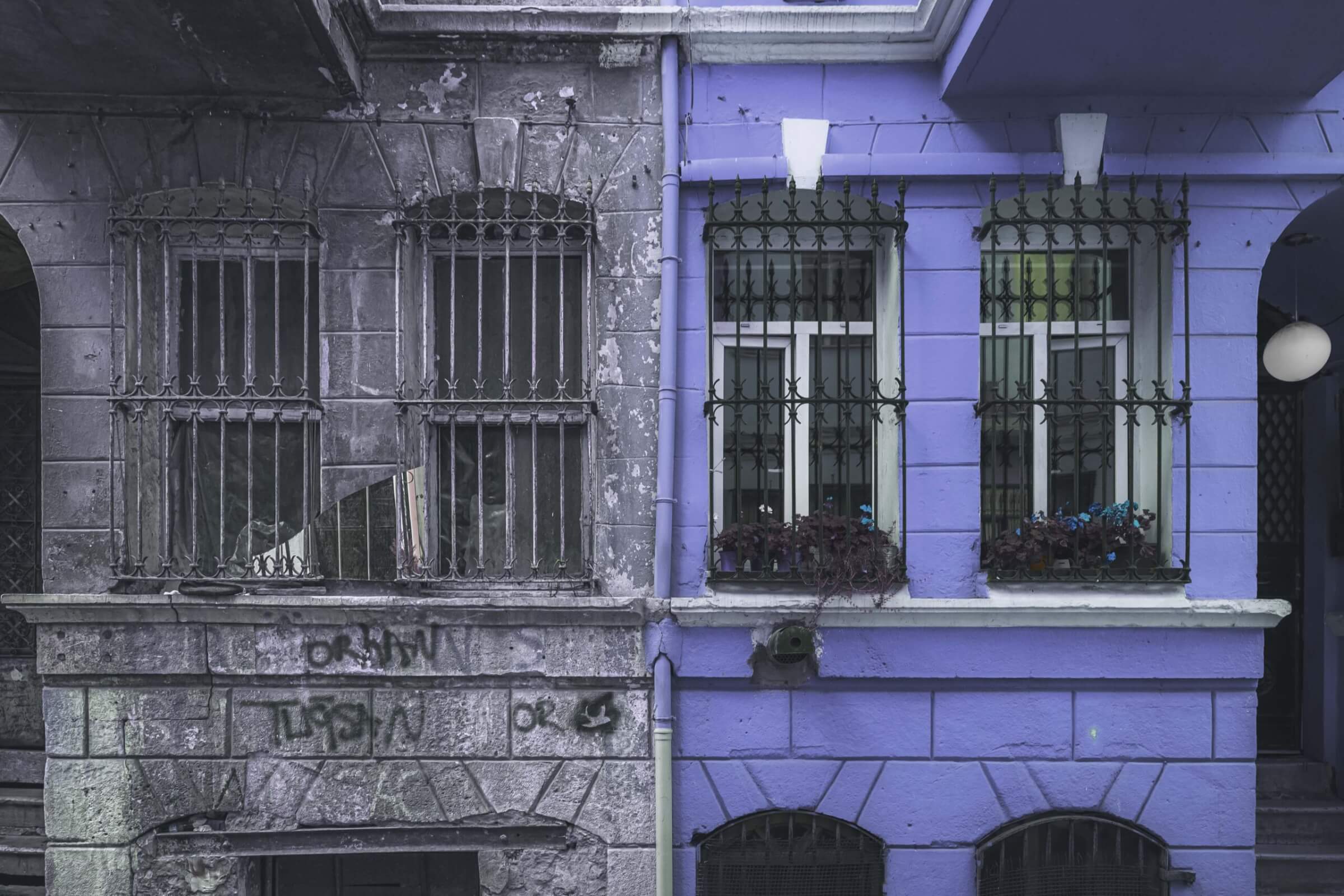 a picture of a purple brick apartment next to a run down grey brick apartment