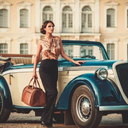 Woman standing beside a vintage car