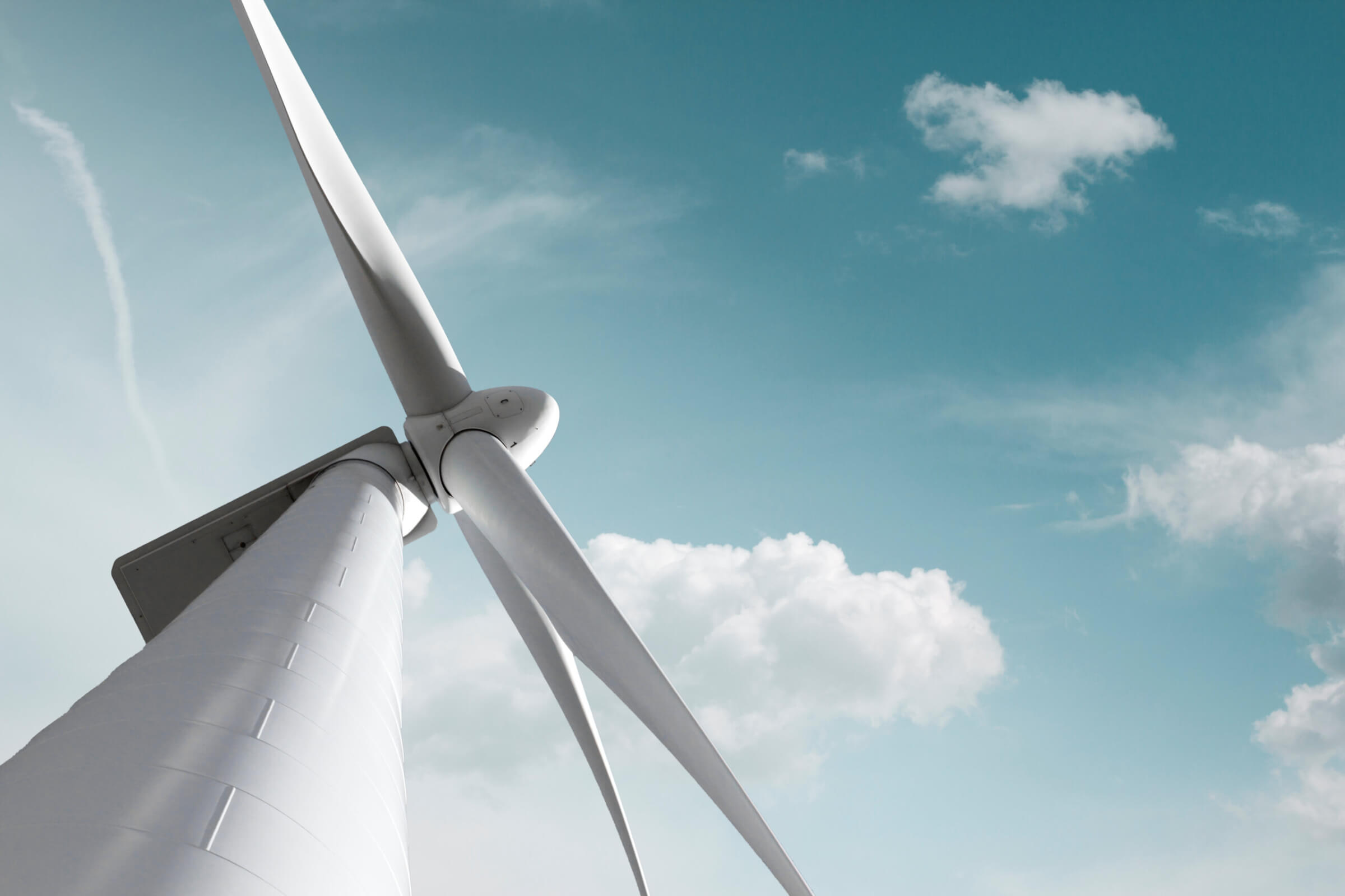 Wind turbine in front of blue sky and clouds