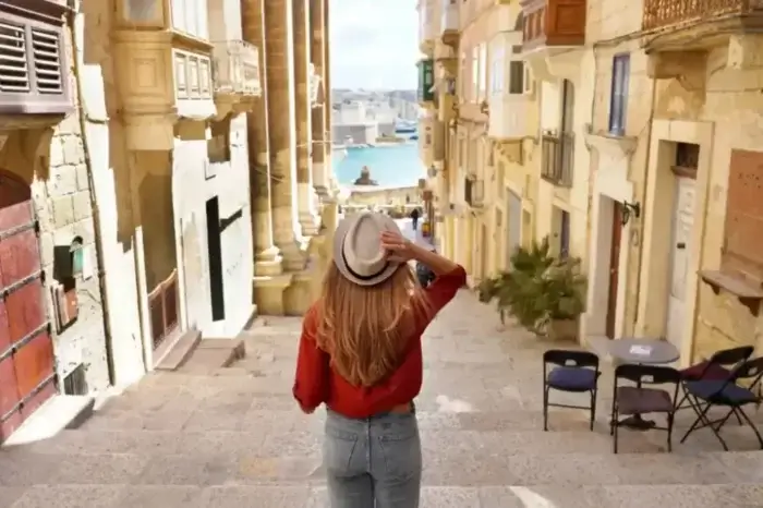 Woman holding hat walking in Malta