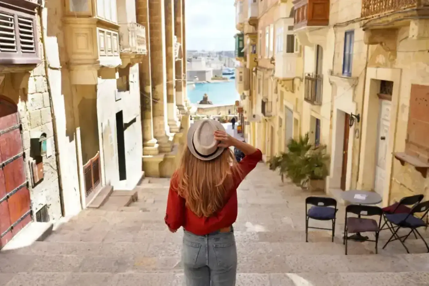 Woman holding hat walking in Malta