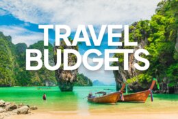 a view of boats on a tropical beach with a title overlay reading "TRAVEL BUDGETS"