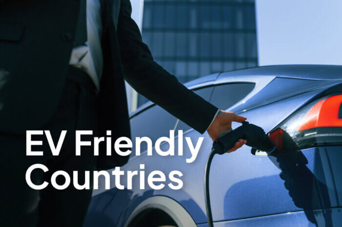 Close-up of a person plugging a charging cable into a blue electric car with ‘EV Friendly Countries’ text overlay.