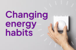 a hand turning a dial with an overlay image of radial lines and a title overlay reading "Changing energy habits"