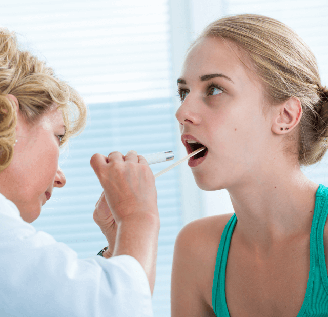 Doctor looking at a patients throat