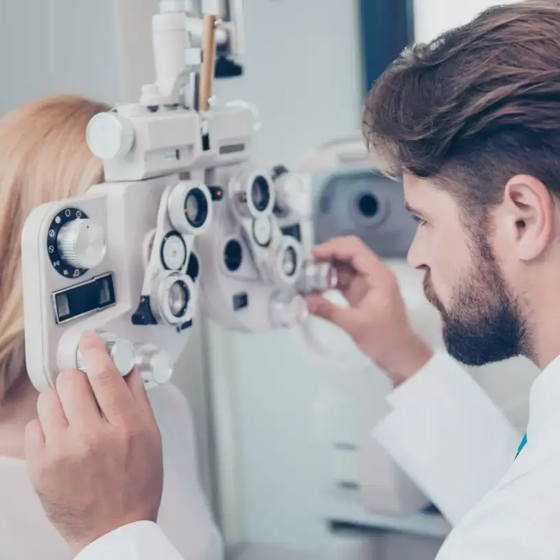 Optometrist does eye test on woman